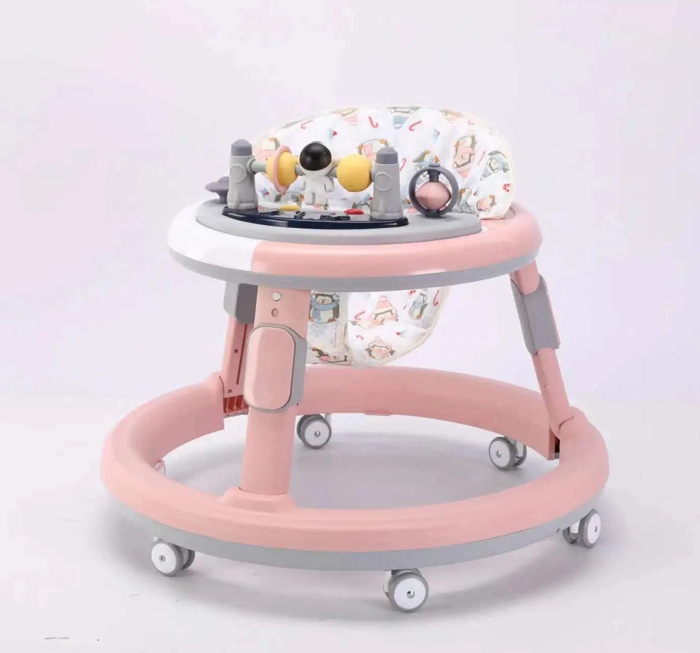 Pink and grey multi-functional baby walker with a rounded base
